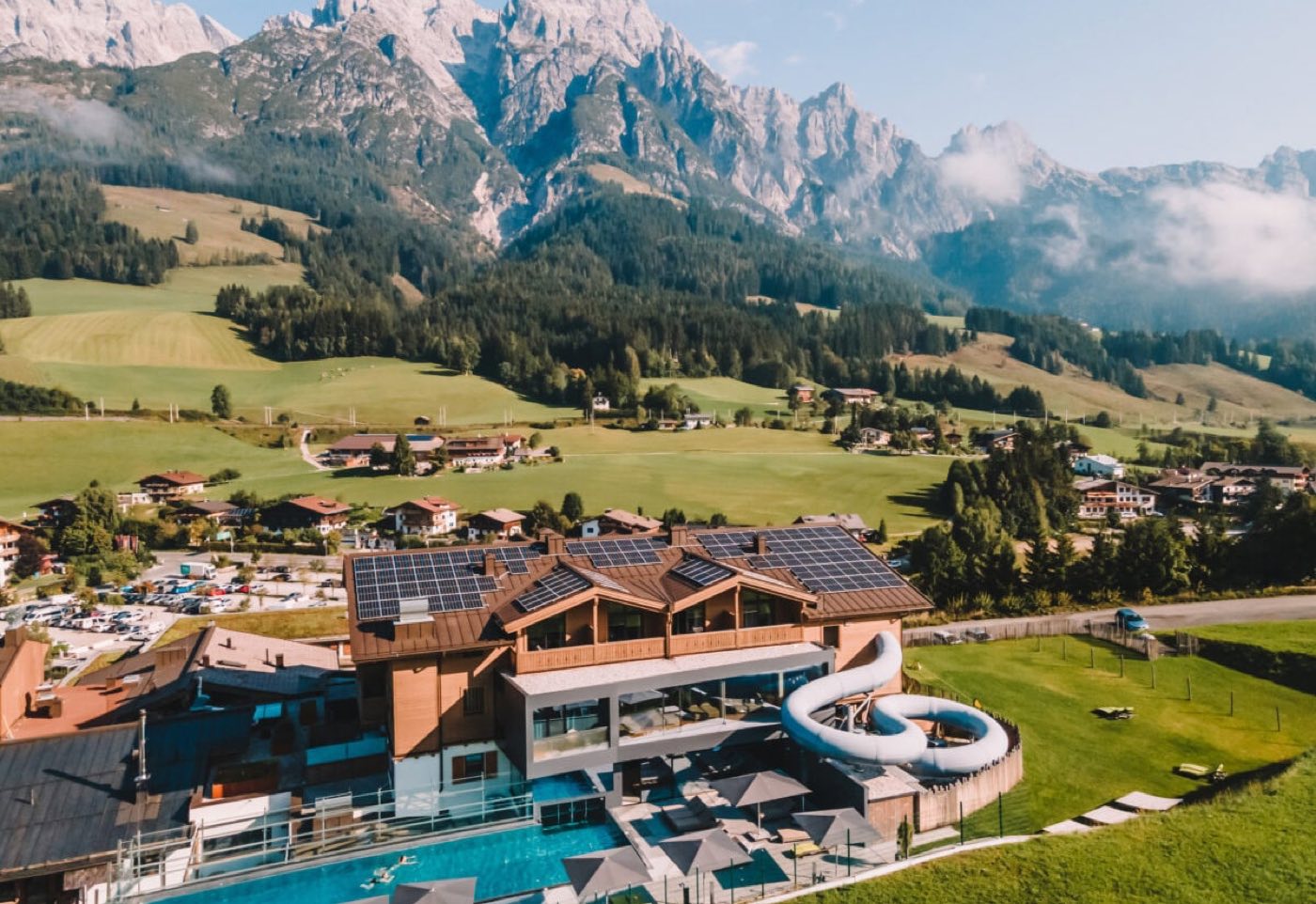 Het hotel in Leogang met het buitenzwembad ervoor en het bergmassief erachter