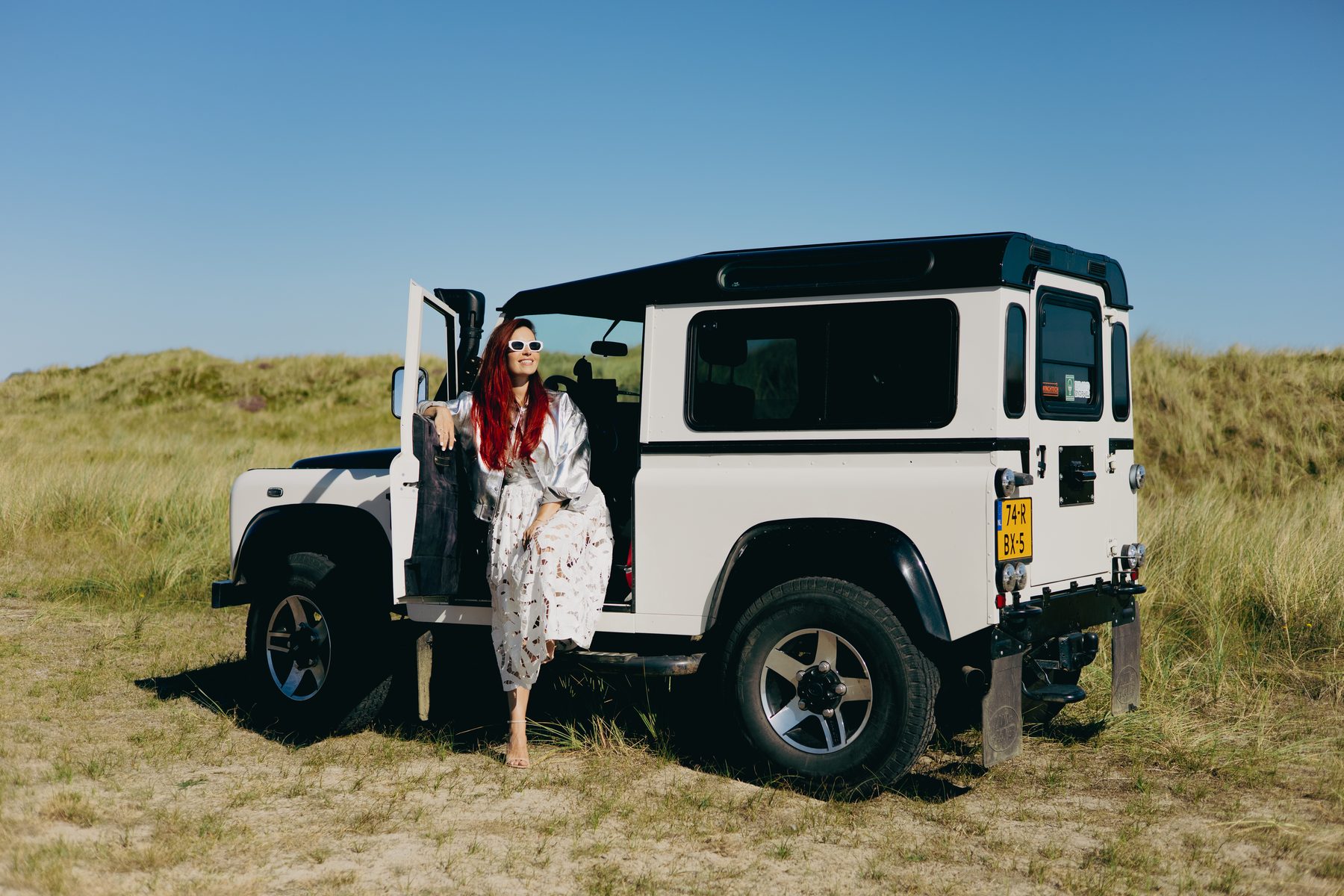 Cynthia bij de Land Rover in de duinen